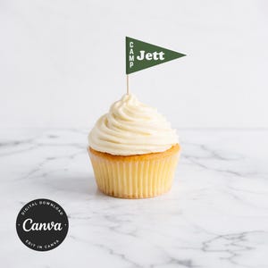 Op de afbeelding: Een cupcake met witte glazuur en een groene vlag met de tekst "CAMP Jett". De cupcake heeft een gele basis en staat op een wit marmeren oppervlak. De afbeelding bevat ook een Canva-logo.
