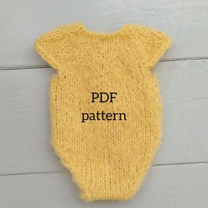 May include: A yellow knitted baby onesie with short sleeves. The onesie has the text "PDF pattern" on the front.
