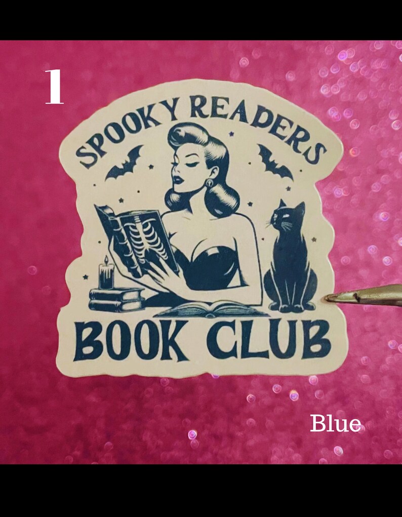 May include: A beige sticker with a black and white illustration of a woman reading a book with a black cat sitting beside her. The sticker says "Spooky Readers Book Club" in a black font.