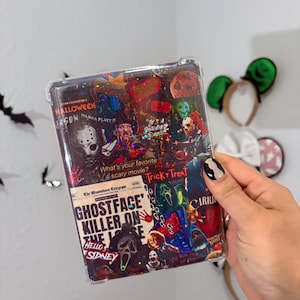May include: A clear phone case featuring a collage of horror movie posters, including "Halloween" and "Ghostface Killer." The case has a glittery, textured appearance with the text "What's your favorite scary movie?" and "Trick or Treat."