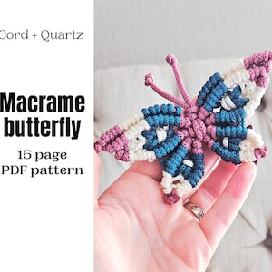 May include: A handmade macrame butterfly in shades of pink, blue, and white. The butterfly has a detailed woven design and is held in a hand. Text on the left reads "Cord + Quartz" and "Macrame butterfly 15 page PDF pattern."
