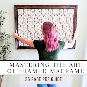 May include: A woman hangs a framed macrame wall hanging with a white and cream pattern. The text "Mastering the Art of Framed Macrame 25 Page PDF Guide" is below the image.