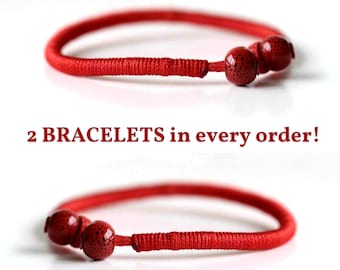 May include: Two red cord bracelets, each featuring a section of tightly wrapped thread and two round red beads with small black speckles. The text 2 BRACELETS in every order! is centered between the two bracelets, which are shown in a horizontal orientation.