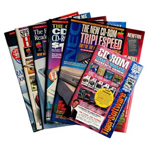 May include: A collection of vintage computer magazines fanned out, featuring titles like The New CD-ROM Triplespeed, CD-ROM Software Buyer's Guide, and TigerSoftware. The covers display various tech graphics, bold typography, and Apple logos.
