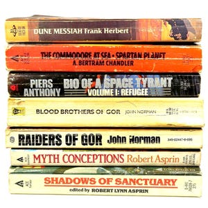 May include: A stack of vintage science fiction and fantasy paperback books. Titles include "Dune Messiah," "The Commodore at Sea," "Bio of a Space Tyrant," "Blood Brothers of Gor," "Raiders of Gor," "Myth Conceptions," and "Shadows of Sanctuary."