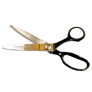 May include: A pair of open scissors with black handles and silver blades. The blades are partially serrated and connected by a gold-colored pivot. The brand name "WISS" is printed on one blade.
