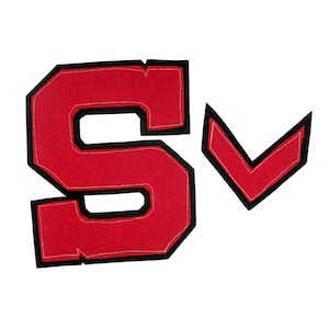 以下が含まれることがあります： 赤色のフェルト文字「S」と、黒い縁取りと金色のステッチが入った赤いシェブロンパッチ。文字「S」は黒い縁取りと金色のステッチが入っています。パッチは、バーシティジャケットなどのアパレル用である可能性があります。