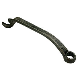Op de afbeelding: Een vintage, gebogen moersleutel met een donkere, getextureerde afwerking. De moersleutel heeft aan één kant een open uiteinde en aan de andere kant een gesloten, veelzijdige kant. De tool is ontworpen voor het aandraaien of losdraaien van bouten en moeren.