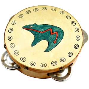 May include: A round tambourine with a light tan drumhead featuring a teal bear design with a red lightning bolt. The wooden frame has metal jingles and a border of black circles. The instrument is set against a white background.