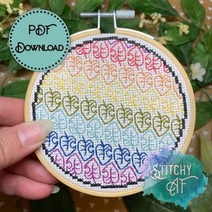 May include: A rainbow-colored embroidery hoop with a pattern of leaves. The hoop is made of wood and has a white fabric background. The text "PDF DOWNLOAD" is visible in the top left corner of the image. The text "STITCHY CAT" is visible in the bottom right corner of the image.