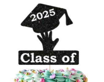 May include: A black glitter graduation cap cake topper with the year 2025 and the words "Class of" on a white banner. The topper is on a cake with blue and white frosting and colorful sprinkles. A white square with gold stars and the text "Ooh Let's Party" is on the cake.