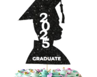 May include: Black and white silhouette of a graduate with a cap and gown, with the year 2025 printed on the side. The silhouette is on a cake topper with the word "Graduate" printed below. The cake topper is on top of a cake with green frosting and colorful sprinkles. A white square with gold lettering says "Ooh Let's Party" with gold stars around the text.