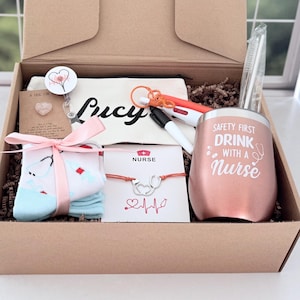 Peut inclure: Coffret cadeau avec des articles sur le thème des infirmières. Comprend un gobelet rose doré avec le texte "SAFETY FIRST DRINK WITH A NURSE", une pochette "Lucy", des chaussettes, un bracelet, des stylos et un porte-badge.