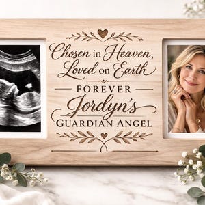 Può includere: Cornice portafoto doppia in legno chiaro con la scritta "Chosen in Heaven, Loved on Earth - Forever Jordyn's Guardian Angel". Un fotogramma contiene un'immagine ecografica, l'altro una foto di una donna. Decorazioni floreali e una candela.