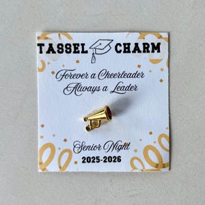 Cheerleader tassel charm graduation keepsake for team banquets senior night or cheer awards designed as a team spirit jewelry accent for girls teens or coaches stylish accessory for tassel keychain or backpack charm for cheerleaders personalized graduation gift idea for teen athletes cheerleaders or cheer moms celebrating end of season or senior year milestones