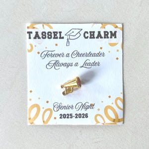 Cheer tassel charm graduation gift for senior night cheerleaders shown on card packaging keepsake accessory for cheer banquet award or team gift perfect for daughters friends and teammates who are celebrating senior year or graduation and want a lasting cheerleading memory for cap tassel bag or scrapbook cheer squad celebration charm jewelry