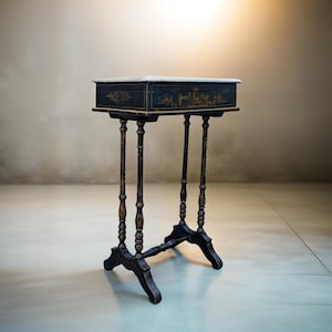 Puede incluir: Una mesa auxiliar negra antigua con tapa de mármol. La mesa presenta detalles dorados ornamentados en el cajón y está sostenida por cuatro patas delgadas y torneadas. Las patas están conectadas por un travesaño inferior. La mesa mide unos 76 cm de alto.