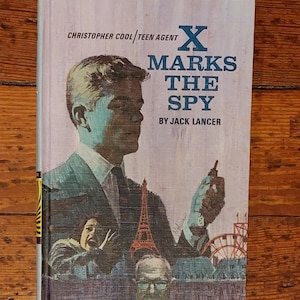 Puede incluir: Portada de libro vintage de "X Marks the Spy" de Jack Lancer. La portada presenta a un hombre con traje sosteniendo un objeto pequeño, con ilustraciones de la Torre Eiffel y un parque de atracciones. El título está en letras azules grandes.