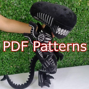 Puede incluir: Un peluche negro de Xenomorfo con detalles blancos, cola larga y cabeza detallada. El texto "PDF Patterns" aparece en rojo. El juguete se muestra sobre un fondo verde.