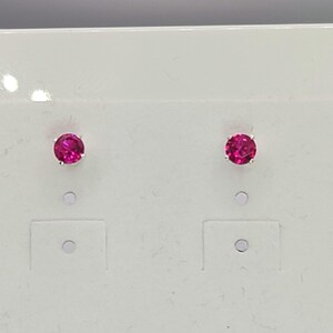 May include: A pair of silver stud earrings with pink gemstones.