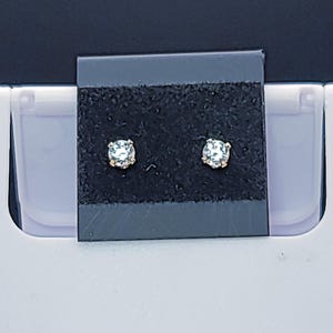 May include: A set of three ceramic mugs with a speckled, matte finish. The mugs are in shades of cream, light gray, and dark gray. Each mug has a simple, minimalist design and a rounded handle.