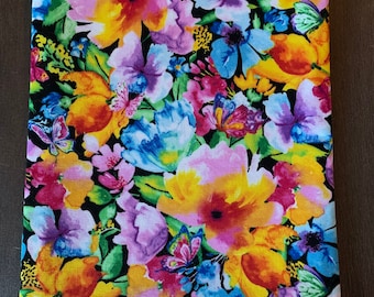 以下が含まれることがあります： ピンク、黄色、青、赤の花と蝶が描かれたカラフルな花柄の黒い布製のポーチ。ポーチは柔らかく、質感のある布地で作られています。