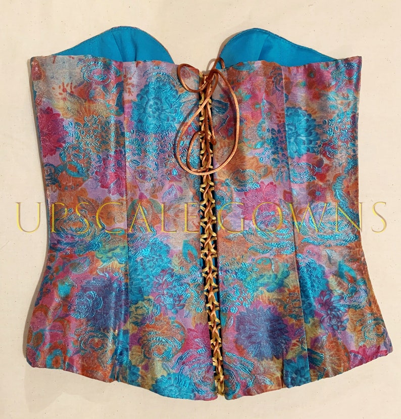May include: A turquoise and pink floral patterned corset with a brown lace-up back.
