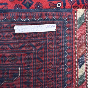 May include: Close-up of a red and blue rug with a fringe border. A handwritten label reads "5.85 x 10.75 meters / 19.2 x 35.2 feet".