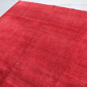 May include: A solid red rug with a smooth, slightly textured surface.