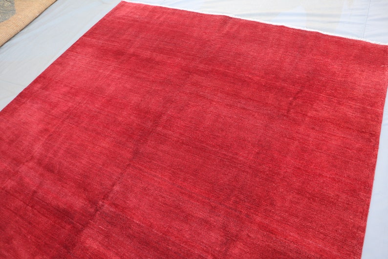 May include: A solid red rug with a smooth, slightly textured surface.