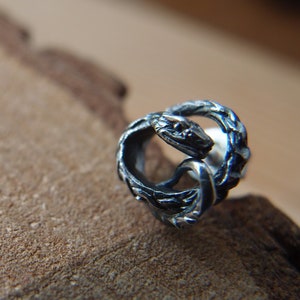 Single Unisex sterling silver stud earring in the shape of uroboros snake or Jörmungandr