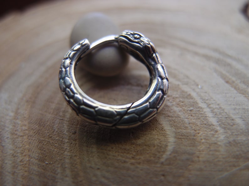 Puede incluir: Pendientes de aro de serpiente de plata con un dise&ntilde;o de serpiente texturizado.