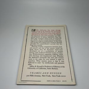 Op de afbeelding: Een boekcover met tekst over de heksenjacht in Europa. De cover is gebroken wit met zwarte tekst. De tekst bevat de titel en de naam van de auteur, Jeffrey B. Russell.