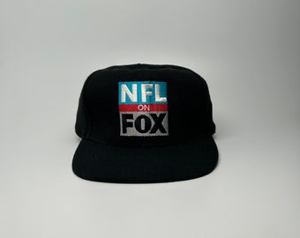 May include: Black baseball cap with a white "NFL on FOX" logo embroidered on the front.