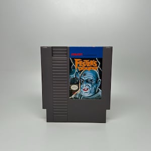 May include: A gray Nintendo Entertainment System (NES) game cartridge. The label features the title "Fester's Quest" with an illustration of a bald, blue-skinned character. The game's logo is in yellow with a lightning bolt design.