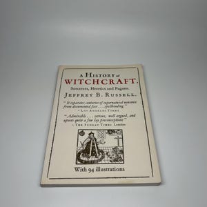 Op de afbeelding: Boek "A History of Witchcraft" van Jeffrey B. Russell. De omslag toont de titel in grote, vette letters, met de ondertitel "Tovernaars, ketters en heidenen". Bevat citaten uit de Los Angeles Times en The Sunday Times London. Het boek heeft 94 illustraties.