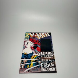 May include: A comic book featuring X-Men characters. The cover art depicts a battle scene with Wolverine and Magneto. The title "Fatal Attractions" is visible, along with the text "The Death of a Dream". The comic is issue #25.