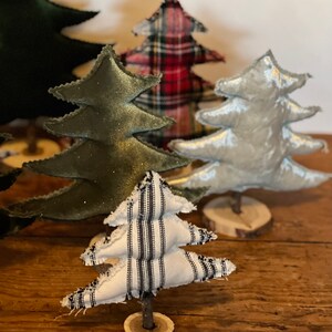 Pu&ograve; includere: Cinque alberi di Natale in miniatura realizzati in tessuto. Gli alberi sono decorati con tessuto a quadri, velluto e strisce. Gli alberi sono seduti su basi di legno.