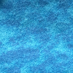 May include: A close-up of a blue textured fabric with a subtle mottled pattern.