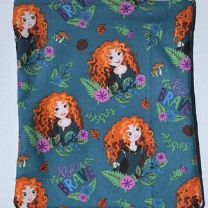 May include: A blue zippered pouch with a repeating pattern of a cartoon girl with red hair, flowers, and the words "be brave".