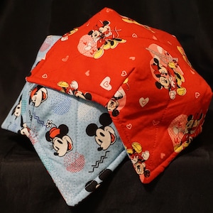 May include: Two fabric bowl cozies, one red with white hearts and Mickey Mouse and Minnie Mouse designs, and one blue with white polka dots and Mickey Mouse and Minnie Mouse designs.