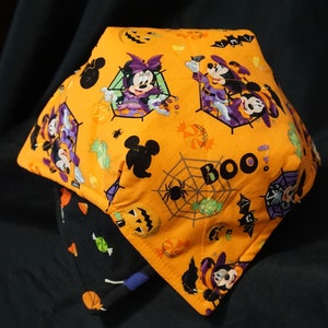 May include: Orange and black Halloween-themed fabric bowl with Mickey Mouse and Minnie Mouse dressed as witches. The bowl has a spiderweb design with the word "BOO!" printed on it.