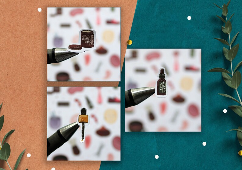 May include: Three stickers on white paper with a pen. The stickers are of a brown jar with the text "Bath Salts", a brown bottle with a green leaf, and a brown dropper with a gold top.