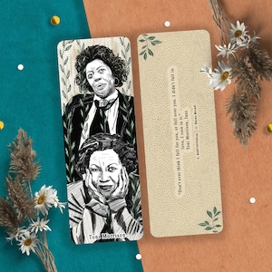 Puede incluir: Dos marcapáginas con ilustraciones de Toni Morrison. Uno muestra dos retratos de Morrison, el otro tiene una cita de su libro, Jazz. La cita dice: "Don't ever think I fell for you, or fell over you. I didn't fall in love, I rose in it."