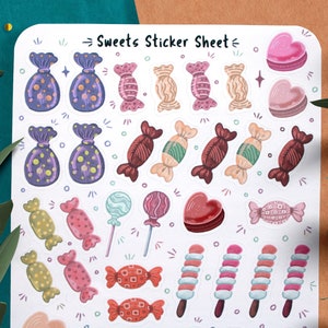 May include: A sticker sheet with a variety of colorful candy and sweet treats. The sheet includes candy canes, lollipops, chocolate hearts, and wrapped candies. The text "Sweets Sticker Sheet" is printed at the top of the sheet.
