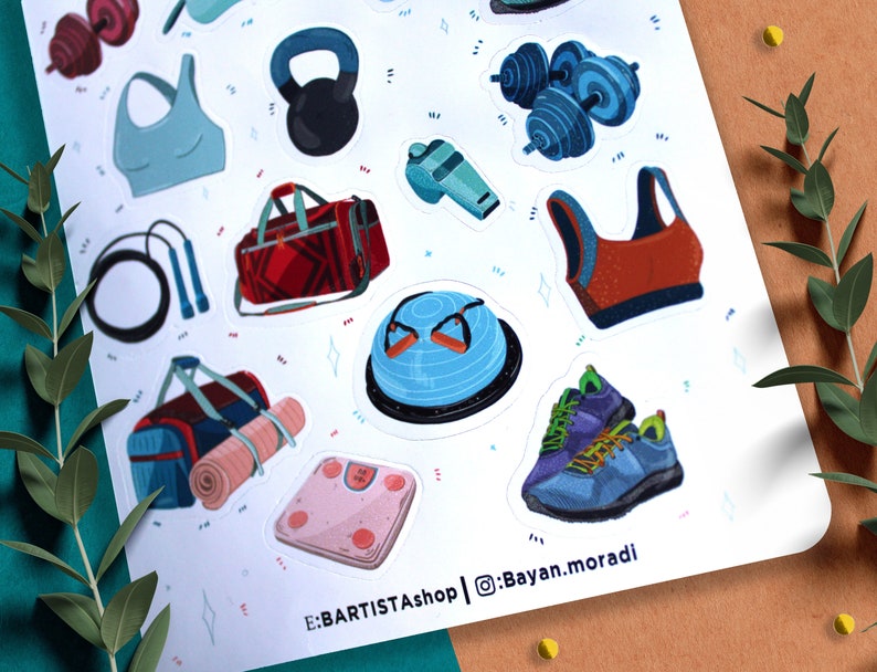 May include: A sheet of colorful stickers featuring various fitness and gym equipment, including dumbbells, a kettlebell, a yoga mat, a jump rope, a sports bra, a gym bag, and a balance ball. The stickers are on a white background with a light blue and pink pattern. The text "E:BARTISTAshop | @Bayan.moradi" is at the bottom of the sheet.
