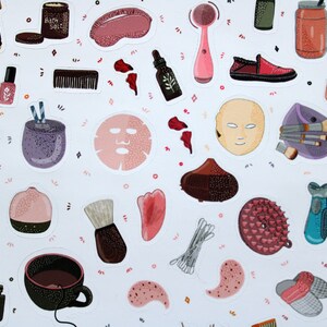 May include: A set of colorful stickers featuring various beauty and self-care items, including face masks, bath salts, brushes, and a facial cleansing brush. The stickers are on a white background with pink and orange accents.