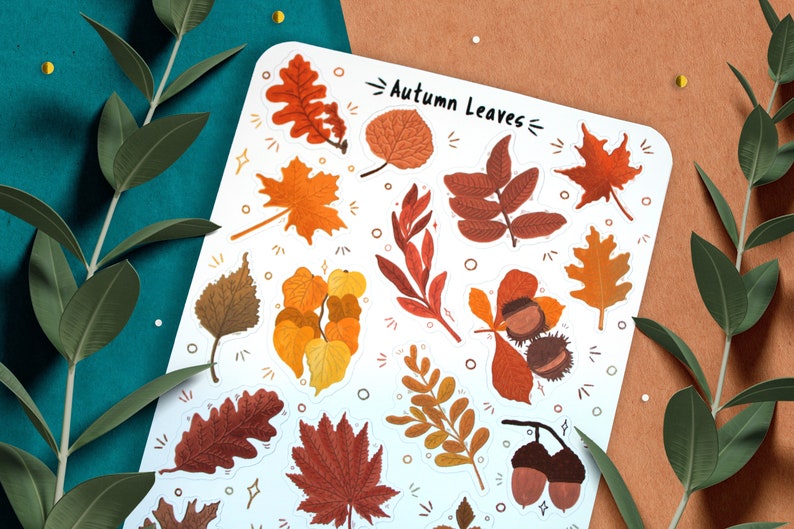 May include: A sheet of stickers featuring various autumn leaves in shades of orange, red, brown, and yellow. The stickers are on a white background and have a title that reads "Autumn Leaves".