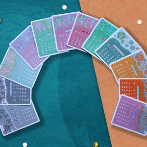Peut inclure: Un ensemble de douze cartes de calendrier illustr&eacute;es, chacune repr&eacute;sentant un mois de l'ann&eacute;e. Les cartes sont dispos&eacute;es en arc, pr&eacute;sentant des illustrations saisonni&egrave;res color&eacute;es et les dates du calendrier. Le fond est un m&eacute;lange de turquoise et d'orange avec des &eacute;l&eacute;ments d&eacute;coratifs.