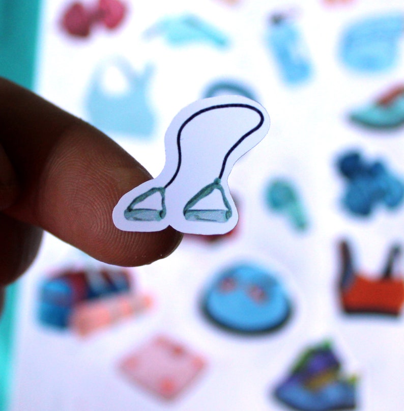 May include: A white sticker with a blue resistance band illustration. The band is looped and has two handles.